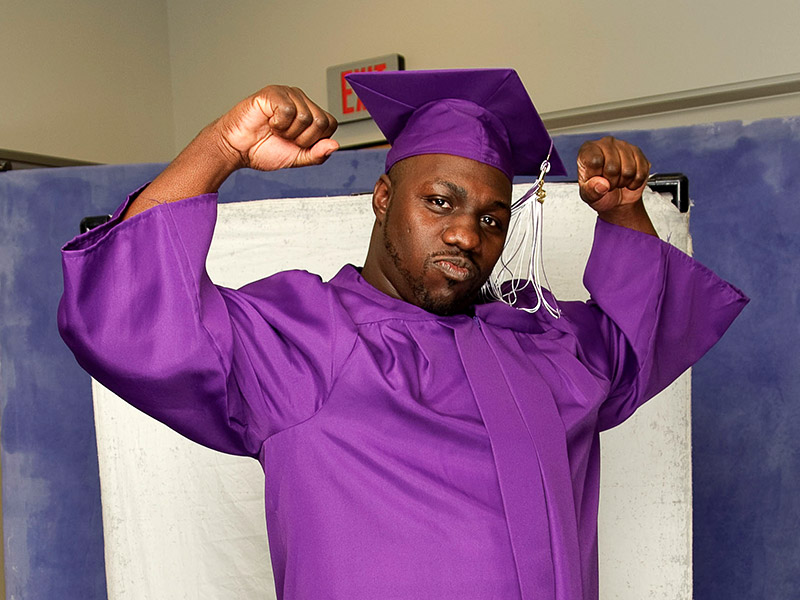 graduate flexing in cap and gown