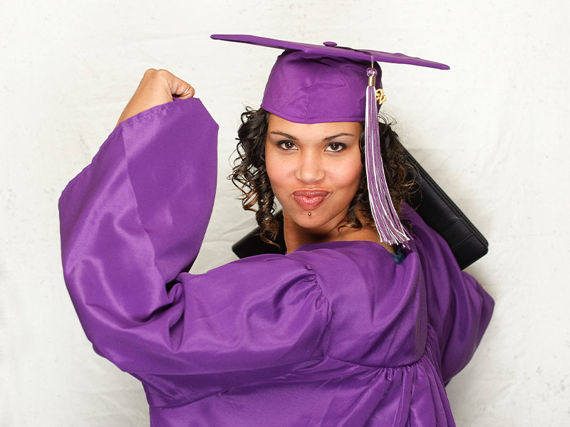 graduate flexing in cap and gown