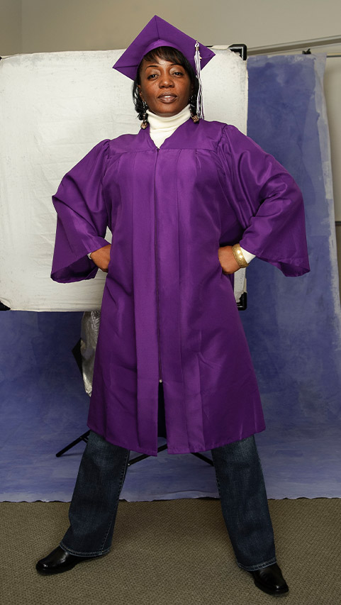 woman standing proudly in cap and gown