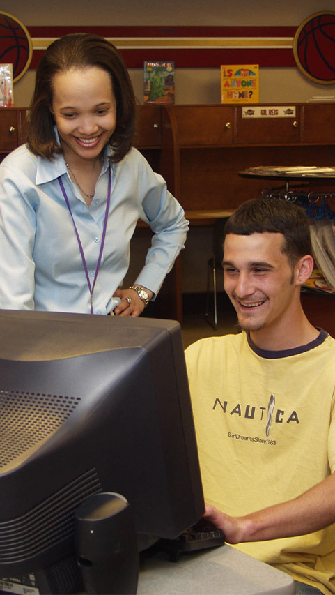 woman tutoring man at computer